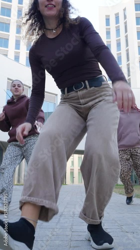 Young women dancing outside modern building