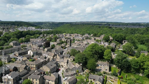 Drone view of the village of Honley featuring St Mary's Church adorned with greenery on a sunny day photo