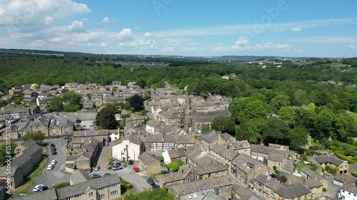 Drone view of the village of Honley Featuring St Mary's Church with lush greenery under clear sky photo