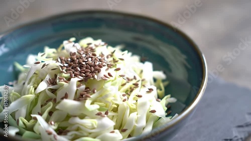 Fresh cabbage salad preparation in a kitchen with healthy toppings and lighting