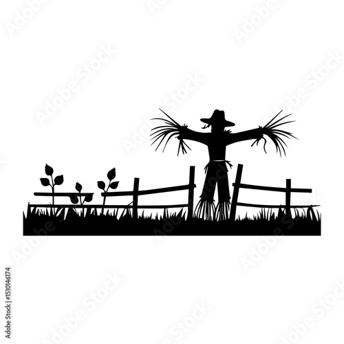 Scarecrow in a field with a fence