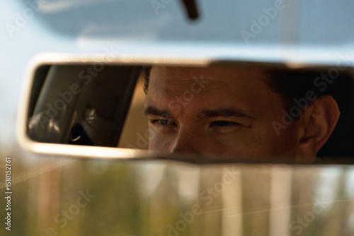 Εκτύπωση καμβά Focused driver's eyes reflect in car mirror, capturing a moment of concentration and introspection during a daytime journey