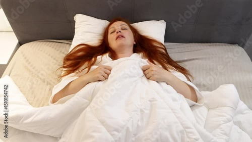 red haired middle aged woman trying to sleep, insomnia and sleep problems, stress at work