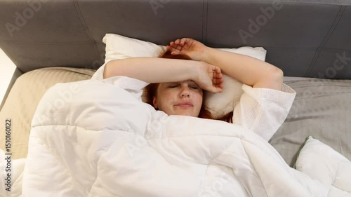red haired middle aged woman trying to sleep, insomnia and sleep problems, stress at work