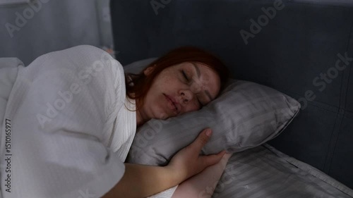 red haired middle aged woman trying to sleep, insomnia and sleep problems, stress at work