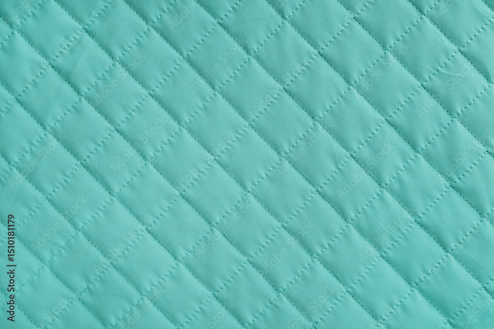 Fototapeta premium Checkered, diamond stitching pattern, turquoise quilted fabric background. Blanket or puffer jacket, stitch rhombus texture close up, macro. Wallpaper, backdrop.
