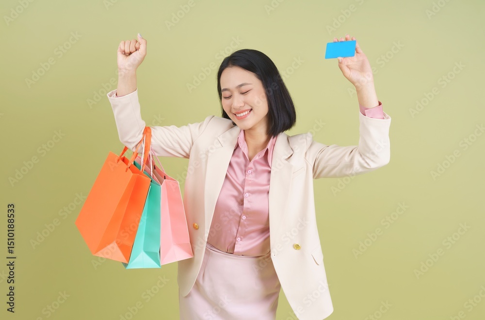 Happy woman celebrating after a successful shopping trip with colorful bags and a credit card held up high indoors Happy woman celebrating after a successful shopping trip with colorful bags and a credit card held up high indoors