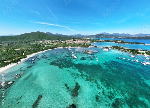 Fototapeta Naklejka Na Ścianę i Meble -  Aerial view of Marinella beach and harbour, white sand beach bathed by a beautiful turquoise water. Marinella Beach, Porto Rotondo, Costa Smeralda, Olbia, north east coast of Sardinia, Italy