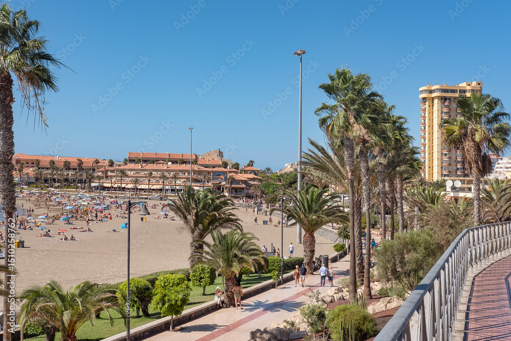 Fototapeta premium Sunny summer day from a vintage point towards the popular beach in the south of the island visited by thousands of tourists yearly at Playa las Vistas, Tenerife, Canary Islands, Spain