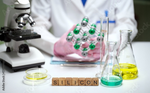 Photos A detailed lab scene with a silicon model, beakers, and a microscope for scienti