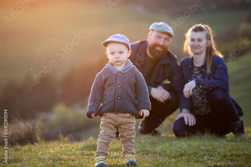 Happy family with a little son enjoying spring sunset outdoor.