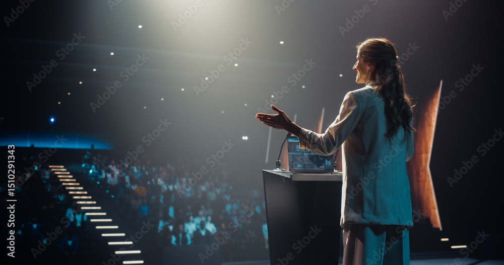 Fototapeta premium Excited Female Entrepreneur Shares an Insightful Talk on Technology and Leadership at a Professional Business Conference. Diverse Multiethnic Guests Sitting in a Dark Auditorium