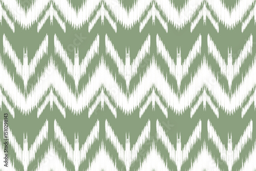 A seamless ikat pattern features blurred sage green zigzag shapes on a white background, creating a vibrant, ethnic textile feel.