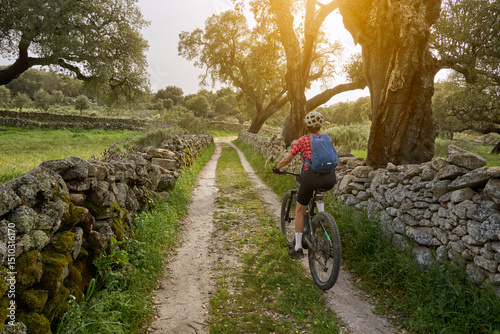 active senior woman cycling with her electric mountain bike in the rough landscape of National Parc Serra de São Mamede near Marvao in central Portugal, Europe