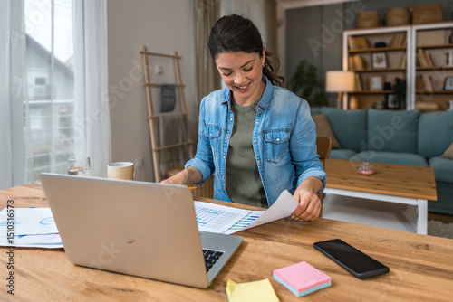 Young woman freelance worker small startup company business owner calculating tax return with data on laptop computer. Working at home office, professional occupation female modern technology user.