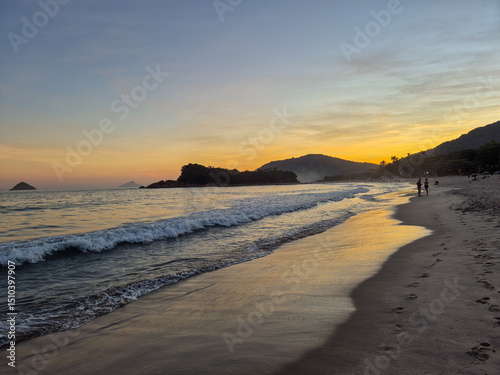 amazing red sunset among the rocks on a tropical beach photo