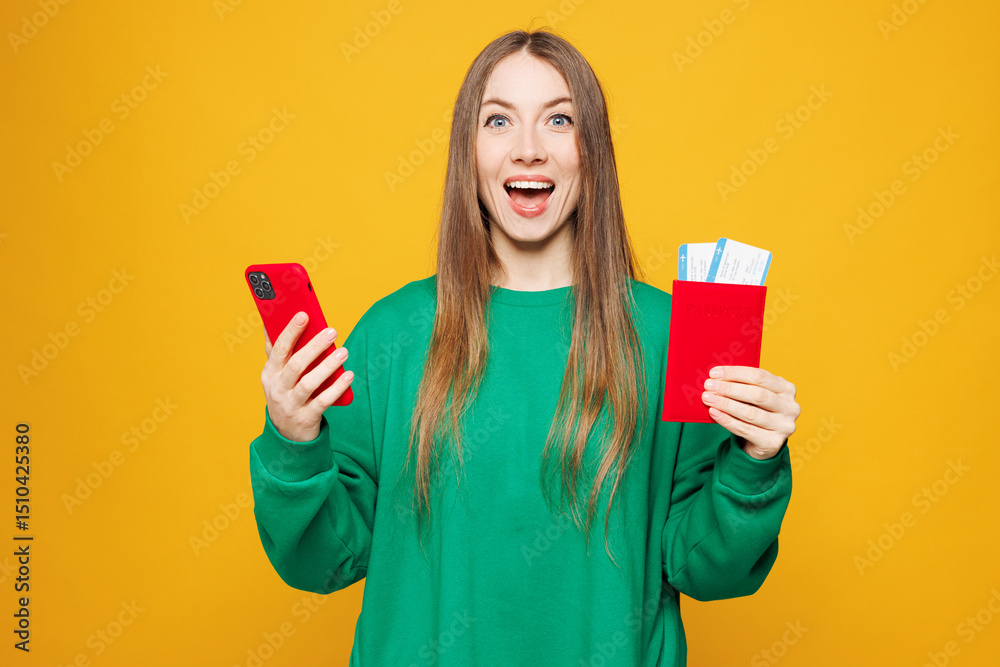 Traveler woman wear green casual clothes hold passport ticket use mobile cell phone isolated on plain orange yellow background. Tourist travel abroad in free time rest getaway Air flight trip concept Traveler woman wear green casual clothes hold passport ticket use mobile cell phone isolated on plain orange yellow background. Tourist travel abroad in free time rest getaway Air flight trip concept