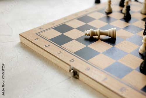 Checkmate. White king chess piece laying down on chessboard after checkmate