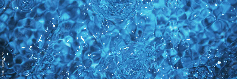 Obraz premium Blue water with ripples. Defocus blurred bleu clear calm water surface texture with splashes and bubbles.