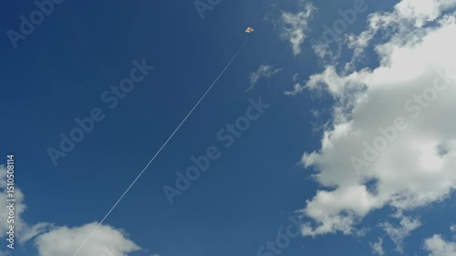 Focused on the string's crisp detail as a kite flies high against soft, clouded
