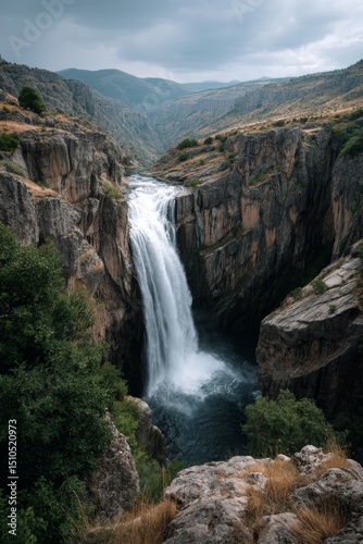 A picturesque mountain river gorge with waterfall cascading through the rocks.