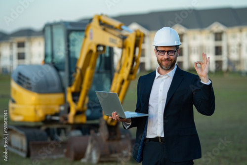 Worker in suit and helmet. Investor civil engineer, construction manager. Construction building developer at a construction site. Successful architect. Handsome hispanic builder man in suit.