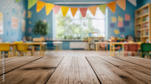 Empty wooden table in a bright colorful classroom with blurred background decoration