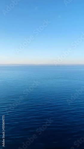 Vertical view of still blue waters and a clean, endless horizon