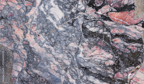 Abstract background of cracked marble fragments. Dark grayish tones.