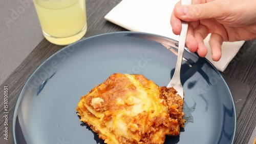 Person Eating Homemade Lasagna with Fork on Blue Plate, 4k