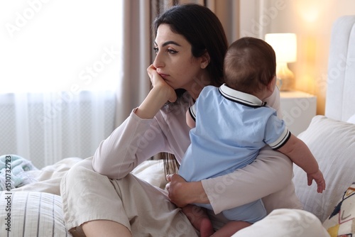 Bild auf Leinwand Woman suffering from postpartum depression with her little baby on bed at home
