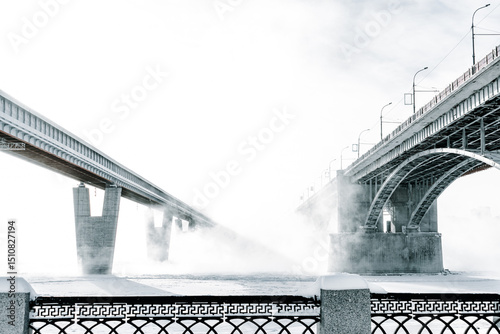 Bridge is over frozen river. Embankment of the Ob river in winter in Novosibirsk frost day -40 degrees Celsius