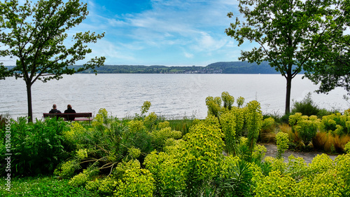 Ein Rentnerpaar genießt auf einer Parkbank am Überlinger Seeufer die herrlicheAussicht auf den Bodensee