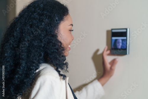 portrait headshot young female african company employee with curly hair standing at time attendance scanner,scanning fingerprint to enter security system