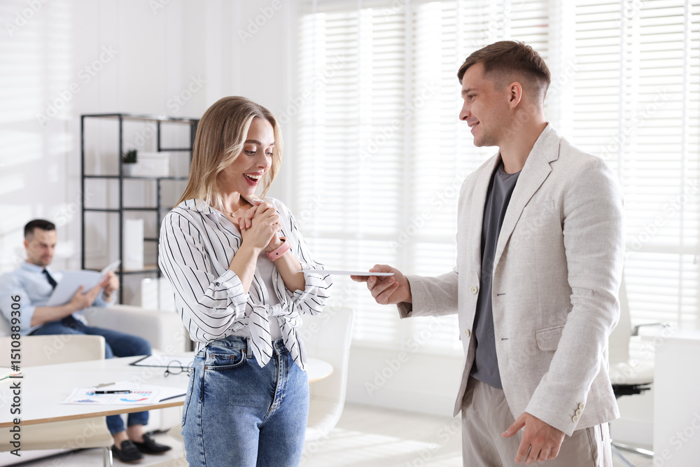 Fototapeta premium Money bonus. Boss giving envelope to employee in office