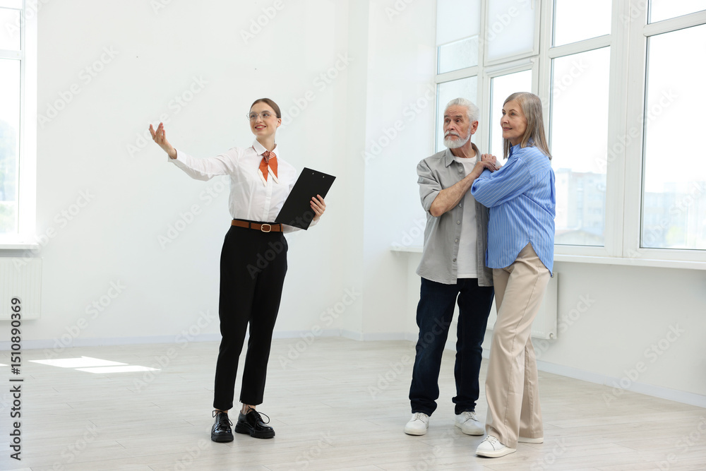 Fototapeta premium Smiling real estate agent showing apartment to couple indoors