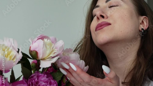 Girl sniffing a bouquet of peonies. Bouquet of flowers