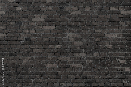 Black wall of black bricks - gloomy room. Industrial building background.
