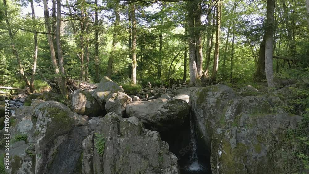 Ruisseau au milieu d'une forêt et empilement de pierre dans les Vosges - Survol en drone