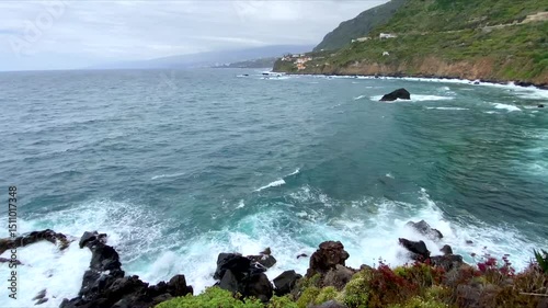 Beautiful view of Las Aguas, San Juan de la Rambla coastline with transparent turquoise blue ocean water and succulent plants in the foreground.Travel or summer vacation concept,4K