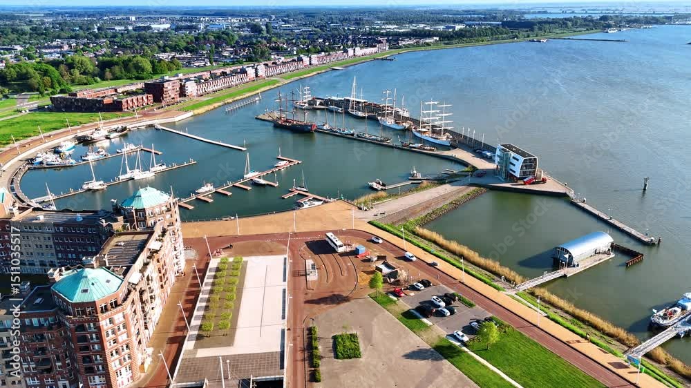 Port of beautiful Lelystad, the Netherlands with some boats and ships at the berths. Approaching the stunning ensemble of buildings at the waterfront of lake Markermeer.