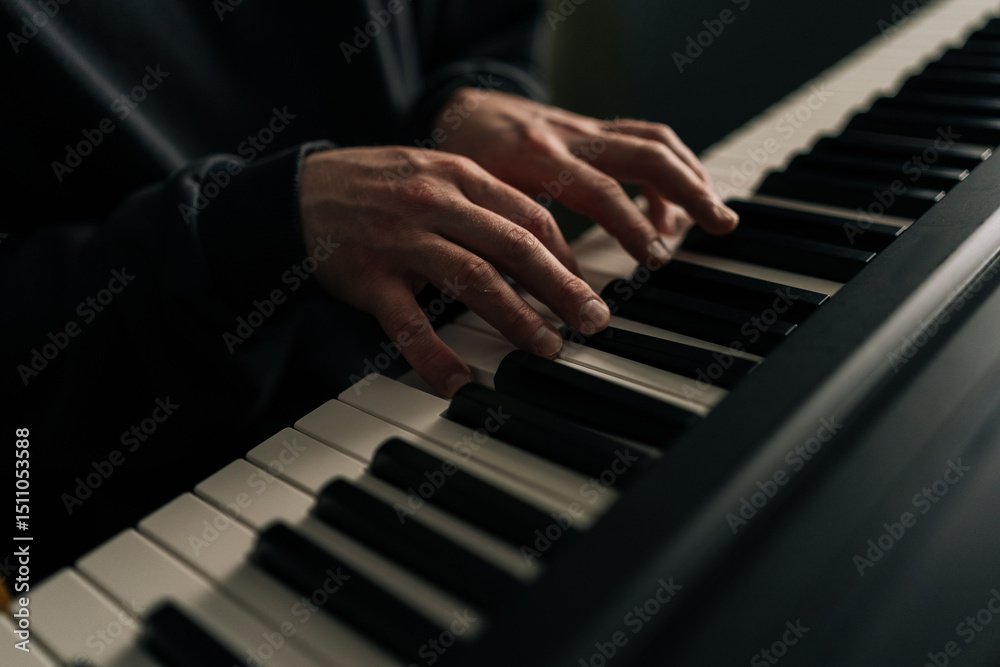 Fototapeta premium Detail cropped shot of unrecognizable pianist male playing synthesizer in home studio, creating melodies, enjoying creative process in personal and inviting space. Concept of recording music at home.