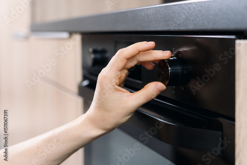 Electric oven control adjustment in a modern kitchen setting