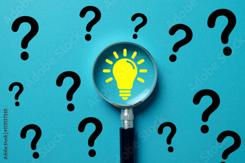 Magnifying glass focusing on a yellow lightbulb idea icon among scattered black question marks. Concept of finding solutions, innovation, problem-solving, creativity,critical thinking.