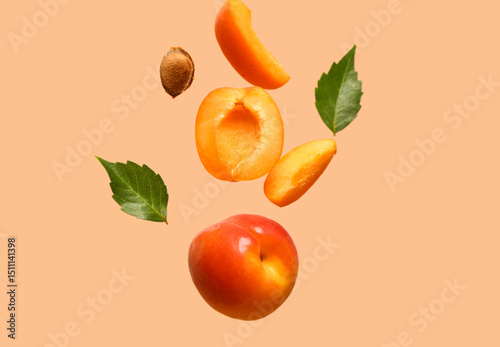 Flying fresh apricot with pieces and leaves on orange background