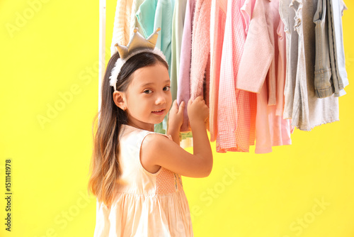 Cute little girl near rack ...