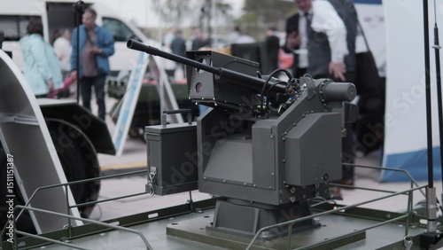 A detailed turreted weapon system is prominently displayed at a defense exhibition, illustrating modern military advancements in weaponry and technology in action.