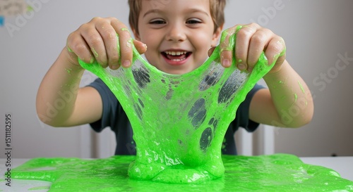 Portrait Little Boy Playing with Green Slime at Table Having Fun