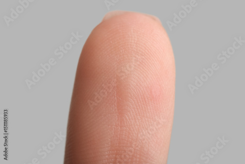 Human fingertip on grey background
