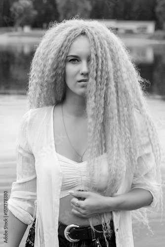 Young beautiful woman standing on the river shore